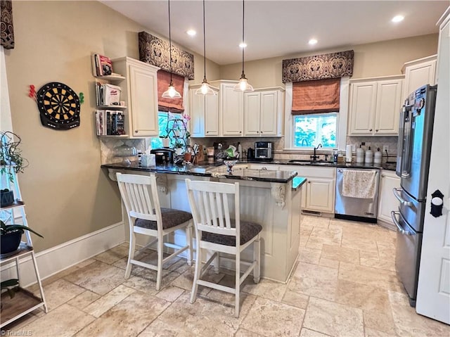 311 Cherry St, Mount Airy, NC 27030 - kitchen featuring appliances with stainless steel finishes, a sink, stone tile flooring, decorative backsplash, and a breakfast bar