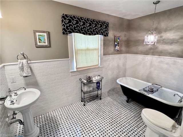 311 Cherry St, Mount Airy, NC 27030 - full bath featuring tile walls, a wainscoted wall, a freestanding bath, a sink, and tile patterned floors