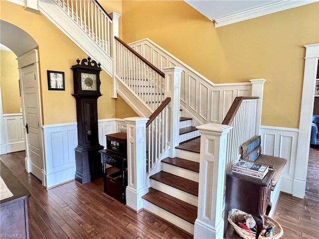 311 Cherry St, Mount Airy, NC 27030 - staircase with arched walkways, wainscoting, ornamental molding, hardwood / wood-style floors, and a decorative wall