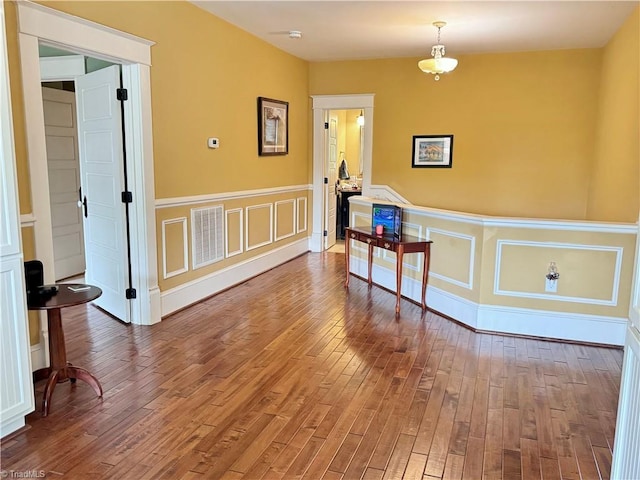 311 Cherry St, Mount Airy, NC 27030 - empty room with wood-type flooring, wainscoting, and a decorative wall
