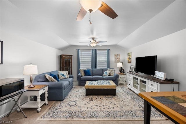 carpeted living area with a ceiling fan and vaulted ceiling