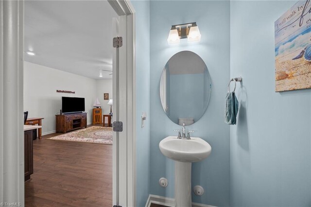 bathroom featuring wood finished floors, a sink, and baseboards