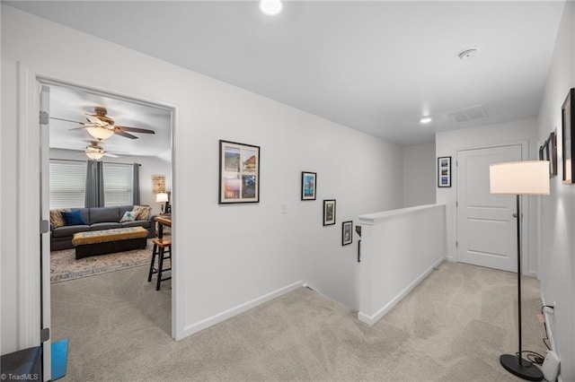 corridor featuring carpet floors, an upstairs landing, and baseboards