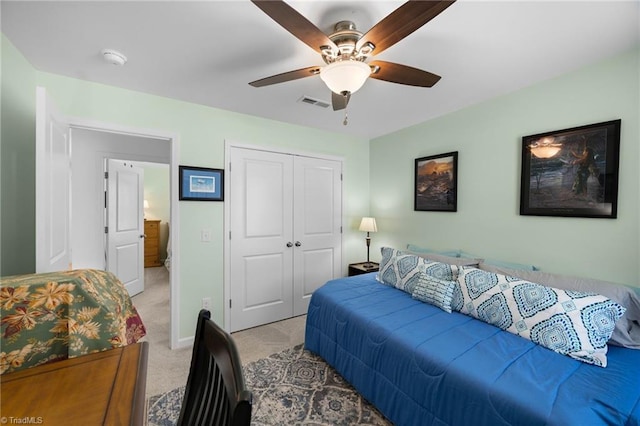 bedroom featuring light carpet, a closet, a ceiling fan, and baseboards