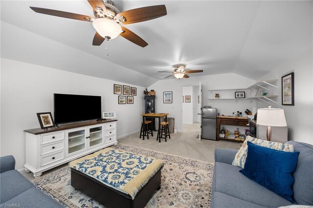 living area featuring ceiling fan, lofted ceiling, light colored carpet, and baseboards