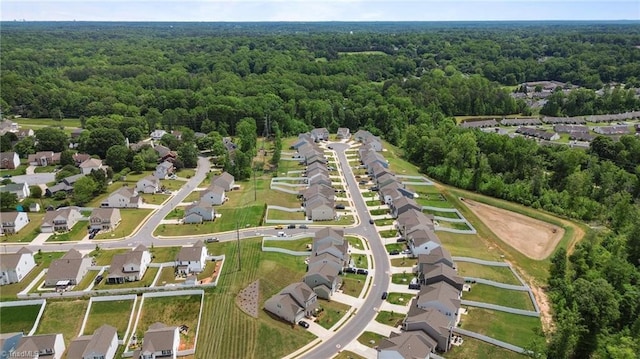 aerial view of property's location featuring a heavily wooded area and nearby suburban area