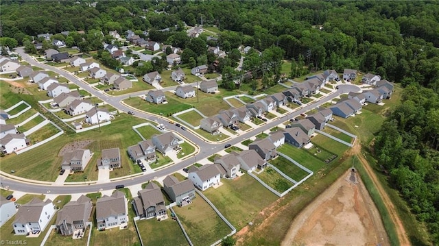 aerial view of property's location featuring nearby suburban area and a forest