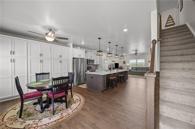 dining space with a ceiling fan, stairs, dark wood-style flooring, and recessed lighting