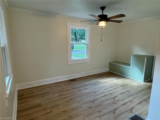 spare room featuring light wood-type flooring, crown molding, and ceiling fan