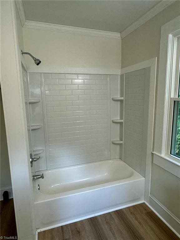 bathroom with shower / bathing tub combination, hardwood / wood-style flooring, and ornamental molding