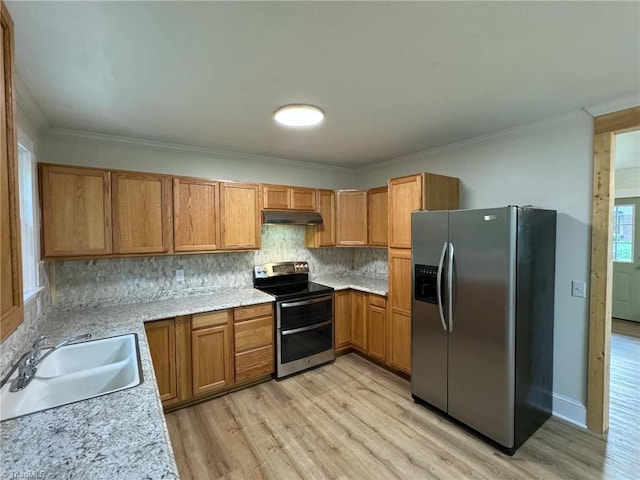 kitchen with sink, appliances with stainless steel finishes, light wood-type flooring, crown molding, and decorative backsplash