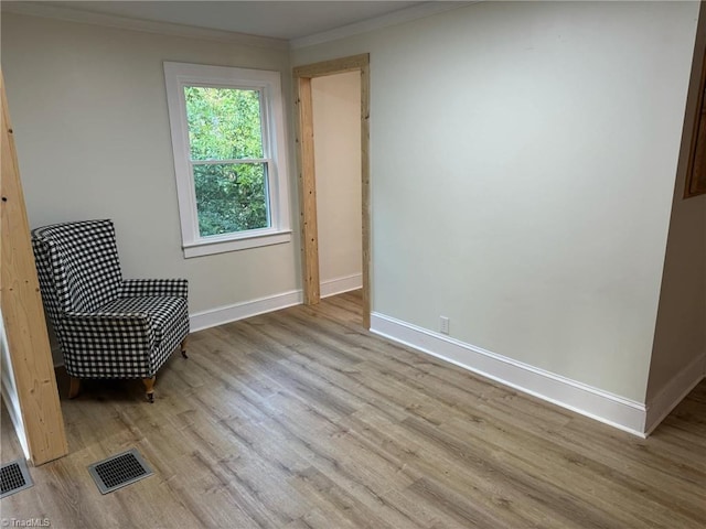 unfurnished room with light hardwood / wood-style flooring and ornamental molding