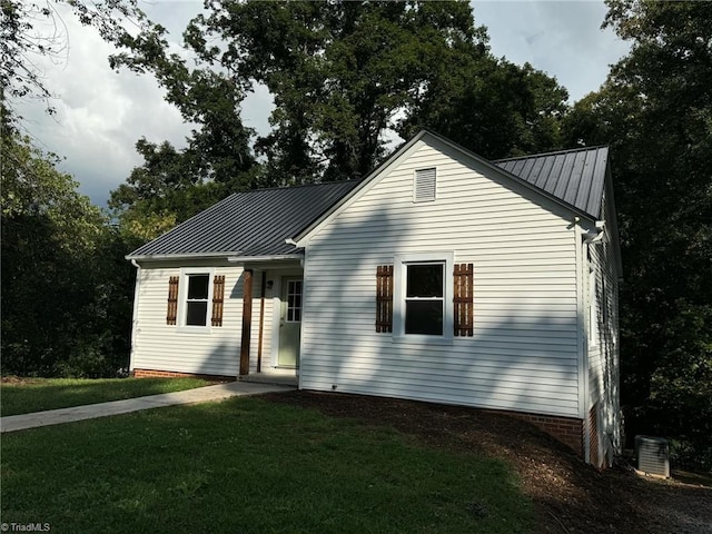 view of front of house featuring a front lawn and central air condition unit