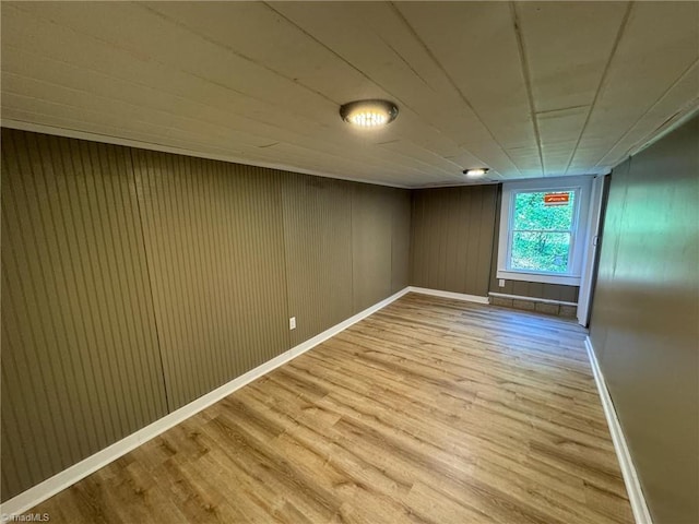 empty room featuring wood walls and hardwood / wood-style floors