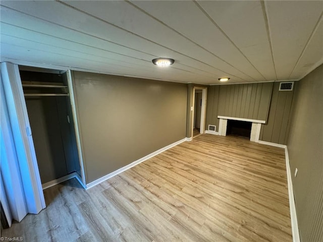 basement with wood walls and hardwood / wood-style floors