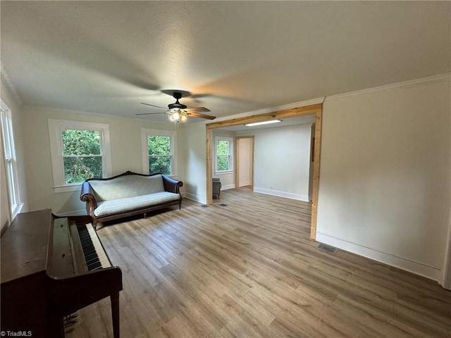 unfurnished bedroom with ceiling fan, a textured ceiling, light hardwood / wood-style flooring, and ornamental molding