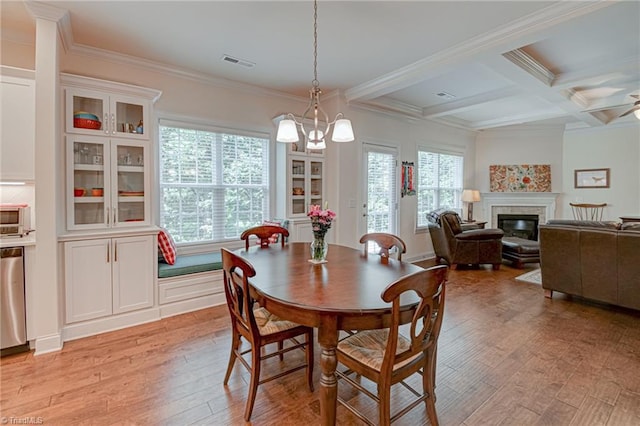 4240 Prestwick Xing, Winston-Salem, NC 27106 - dining space featuring light wood-style flooring, beamed ceiling, a glass covered fireplace, ornamental molding, and coffered ceiling
