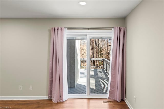 entryway featuring visible vents, wood finished floors, and baseboards