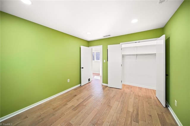 unfurnished bedroom featuring visible vents, baseboards, light wood-type flooring, recessed lighting, and a closet