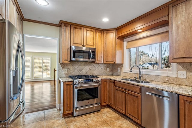 kitchen with sink, light tile patterned floors, stainless steel appliances, light stone counters, and decorative backsplash