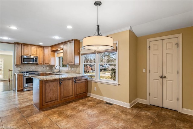 kitchen with decorative light fixtures, light stone countertops, kitchen peninsula, and appliances with stainless steel finishes