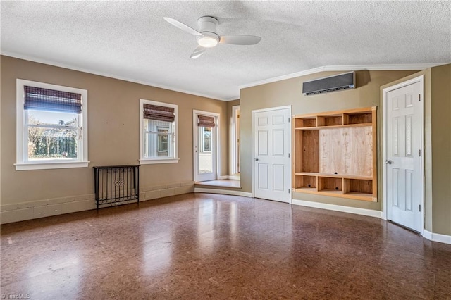 spare room with ceiling fan, a textured ceiling, and a wall unit AC