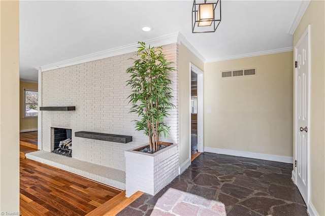 foyer entrance with brick wall, crown molding, a brick fireplace, and dark hardwood / wood-style floors