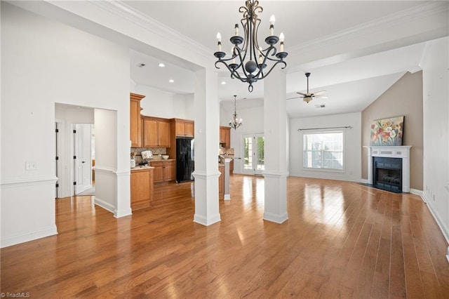 unfurnished living room featuring light wood-style floors, baseboards, recessed lighting, a fireplace with flush hearth, and ceiling fan with notable chandelier