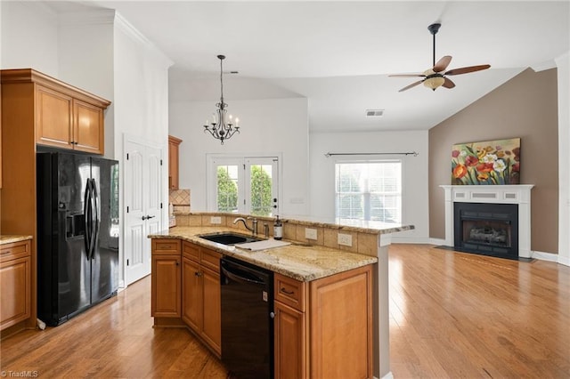 kitchen with light wood-type flooring, a sink, lofted ceiling, and black appliances