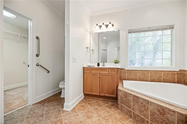 full bathroom with vanity, ornamental molding, a garden tub, toilet, and a walk in closet
