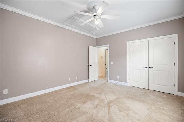 unfurnished bedroom with crown molding, light colored carpet, a ceiling fan, baseboards, and a closet