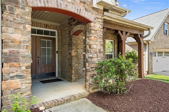 view of exterior entry with brick siding and stone siding