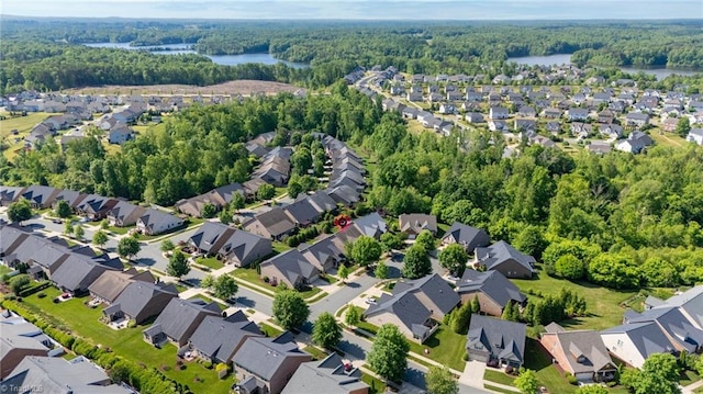 drone / aerial view with a residential view, a view of trees, and a water view