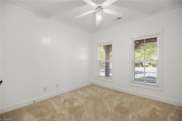 carpeted empty room with a ceiling fan, baseboards, visible vents, and ornamental molding