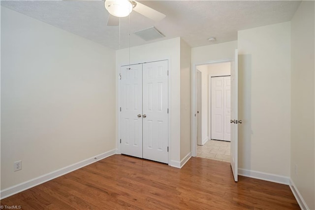149 Royal View Dr Unit 1, Pinnacle, NC 27043 - unfurnished bedroom featuring wood finished floors, baseboards, ceiling fan, a closet, and a textured ceiling
