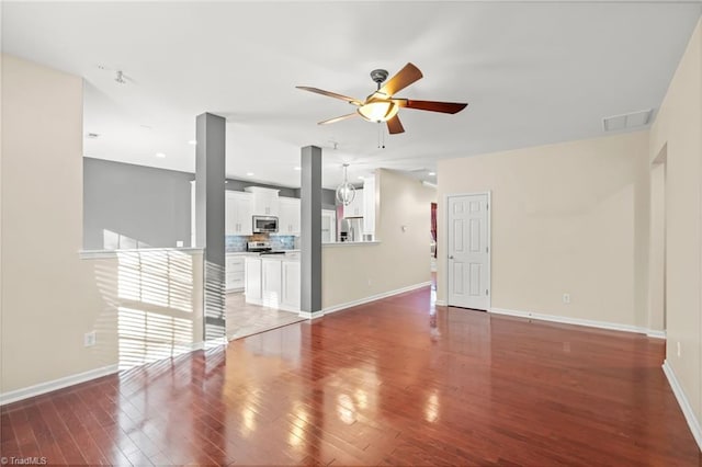 unfurnished living room with ceiling fan and dark wood-type flooring