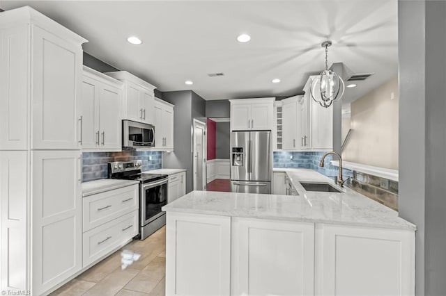 kitchen featuring pendant lighting, white cabinetry, sink, and appliances with stainless steel finishes