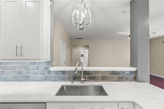 kitchen featuring white cabinetry, sink, and light stone counters