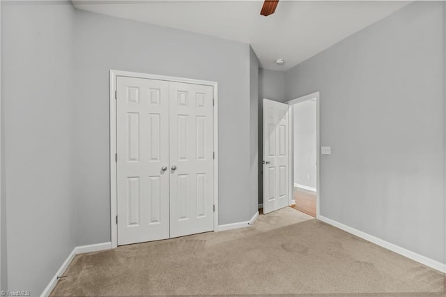 unfurnished bedroom with ceiling fan, a closet, and light colored carpet