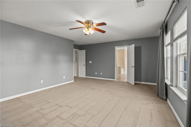 carpeted spare room with a wealth of natural light and ceiling fan