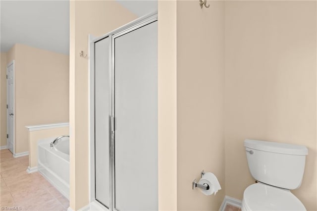 bathroom with tile patterned floors, a tub, and toilet