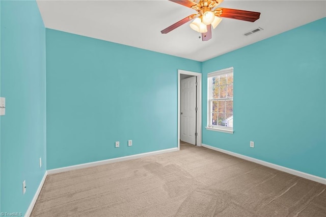 carpeted spare room featuring ceiling fan