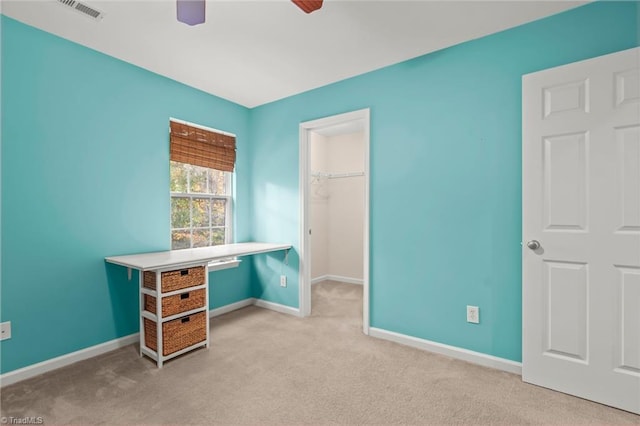 carpeted home office featuring ceiling fan