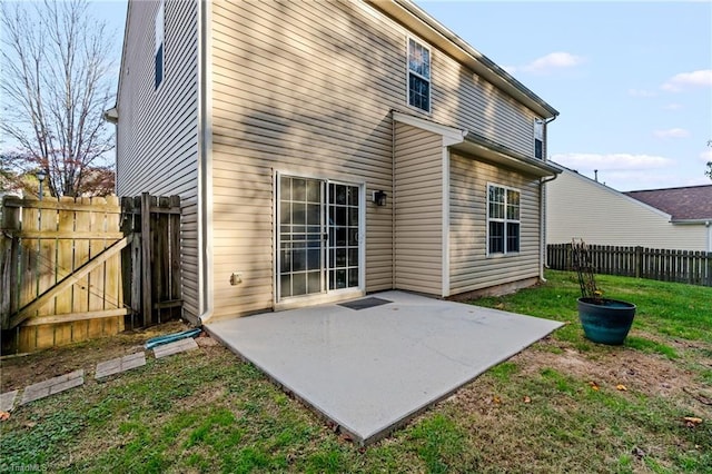 back of property with a lawn and a patio area