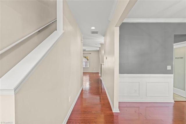 hallway with hardwood / wood-style flooring and ornamental molding