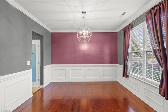 unfurnished dining area featuring crown molding, hardwood / wood-style floors, and an inviting chandelier