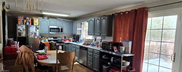 kitchen with stainless steel appliances, ornamental molding, and wood-type flooring