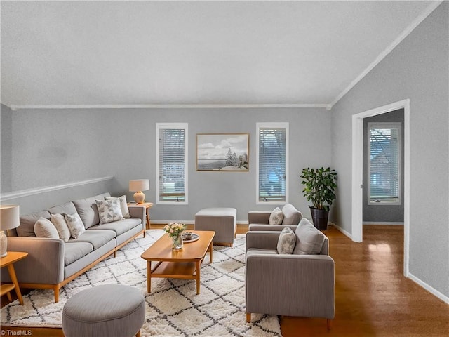 living area featuring vaulted ceiling, wood finished floors, baseboards, and ornamental molding