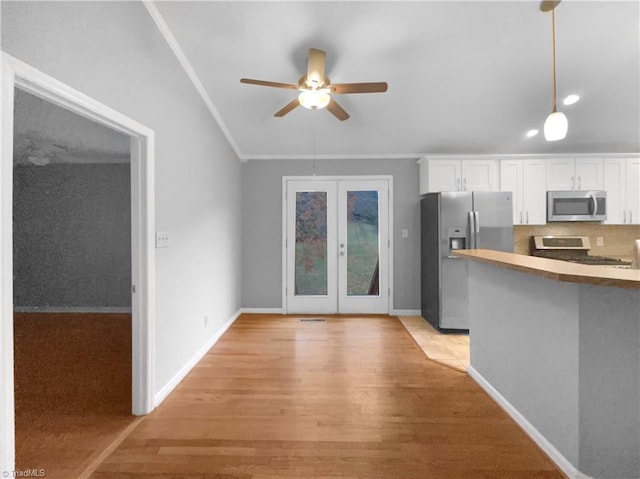 kitchen featuring a ceiling fan, light wood-style flooring, stainless steel appliances, french doors, and white cabinetry