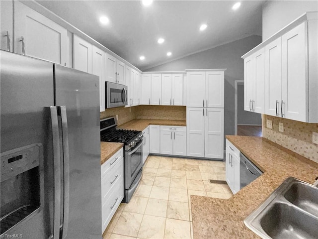 kitchen featuring a sink, recessed lighting, appliances with stainless steel finishes, white cabinets, and lofted ceiling